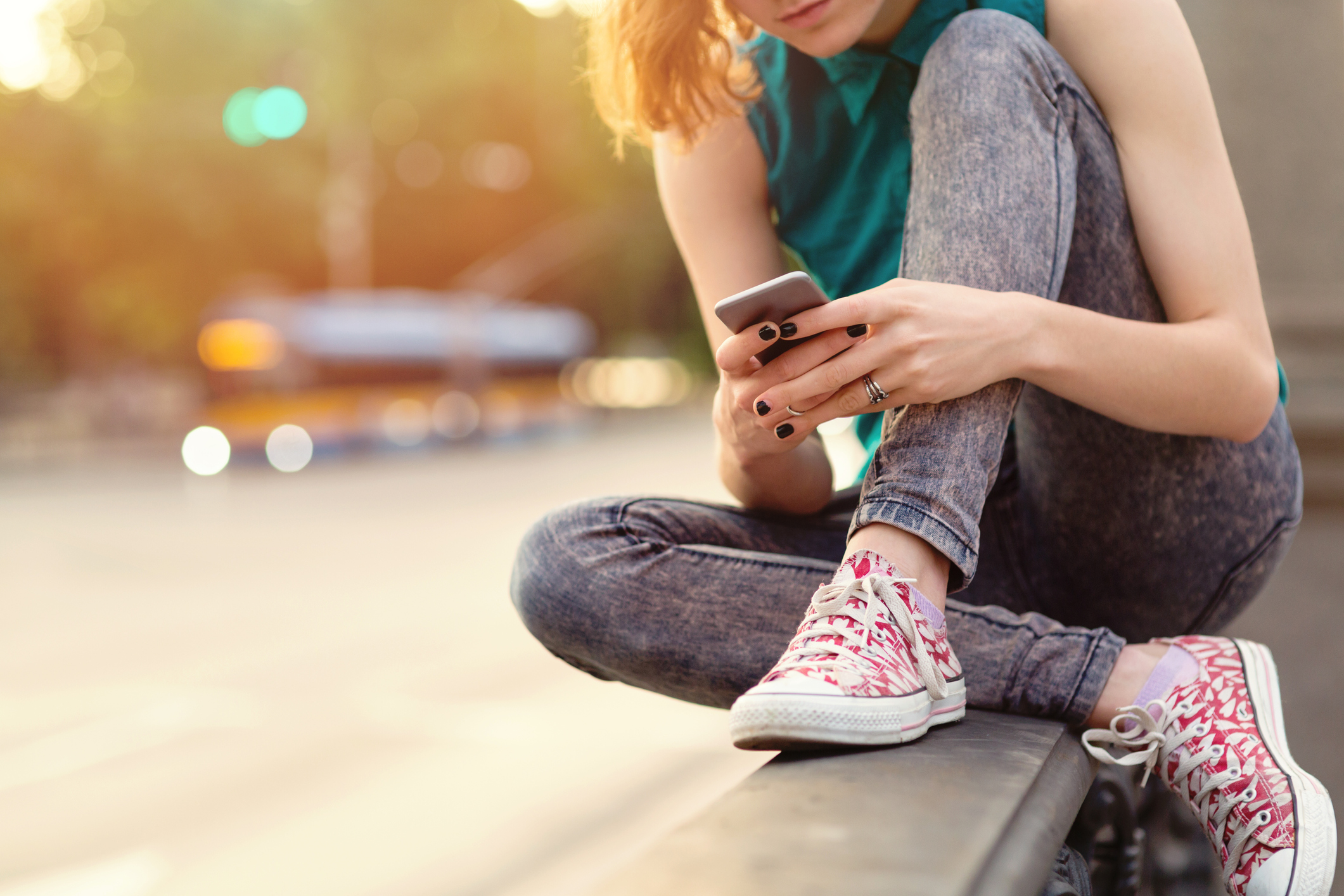 Une adolescente défile sur son téléphone