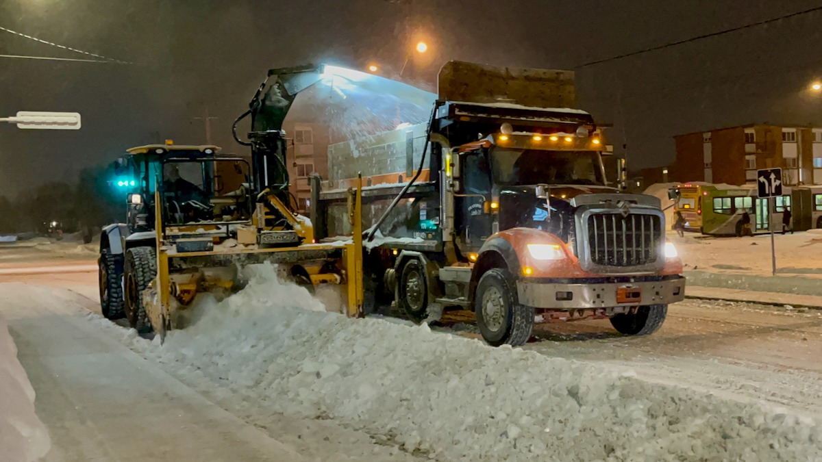 Une déneigeuse souffle la neige dans un camion pendant une opération de chargement de la neige.